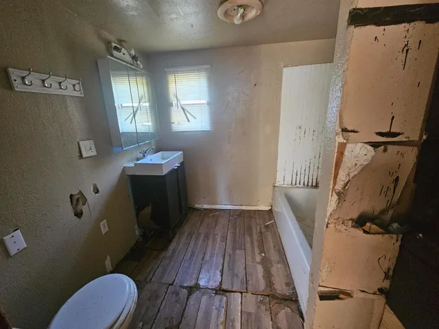 a bathroom with sink toilet and window