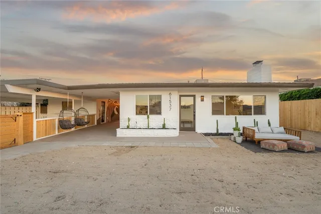 a view of a house with backyard sitting area and balcony
