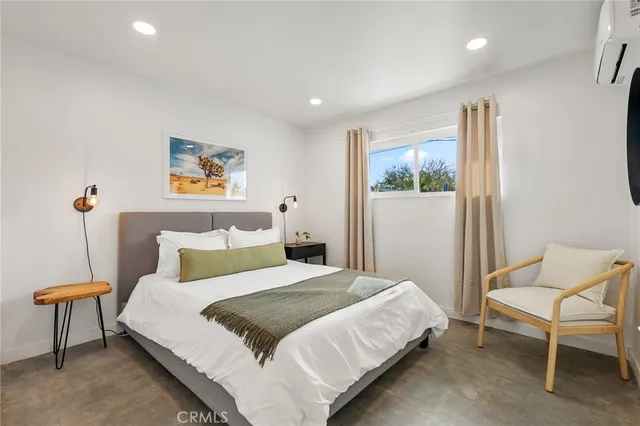 a bedroom with a bed and a lamp on dresser