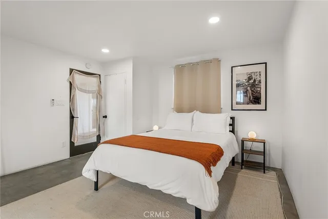 a bedroom with a bed and a washing machine in it