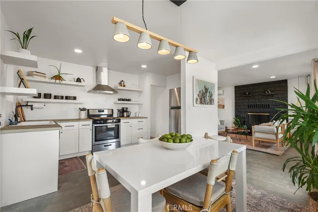 a kitchen with a dining table chairs and white appliances
