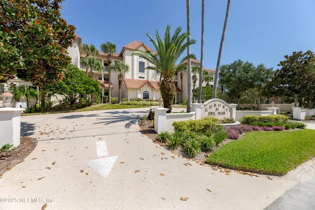 a view of a white house with a yard and plants