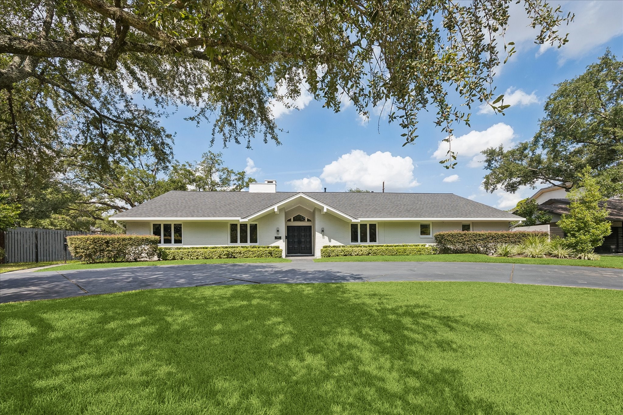 5698 Bayou Glen Road Houston, TX 77056 - Photo 1 of 30 Beautifully appointed single-story home with a welcoming front entrance and situated on a professionally landscaped lot with mature trees and a circular driveway.