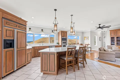 a large kitchen with kitchen island granite countertop a sink a counter top space and stainless steel appliances