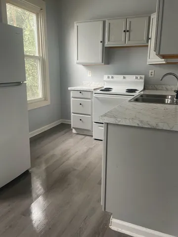 a kitchen with granite countertop a sink a stove and cabinets