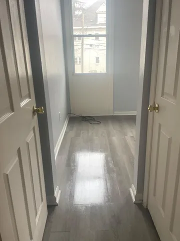 a view of empty room with wooden floor