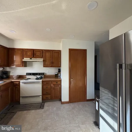 a kitchen with stainless steel appliances granite countertop a refrigerator and a stove