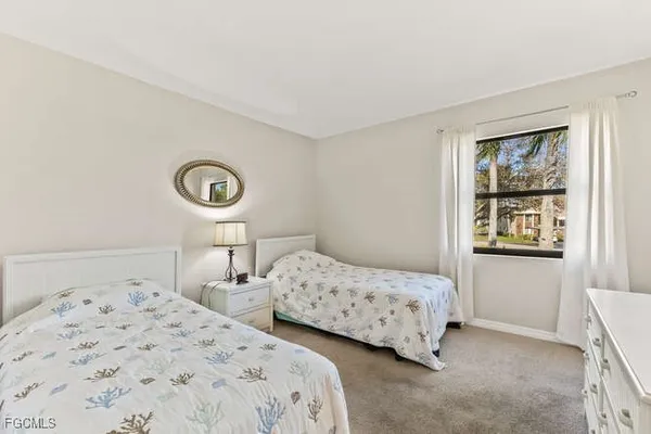 a bedroom with two beds and a window