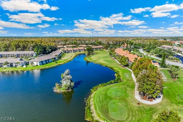 a view of a lake in front of residential houses with outdoor space