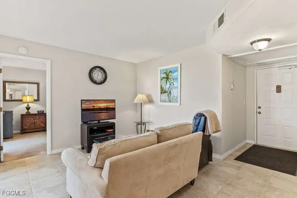 a living room with furniture a couch and dresser with wooden floor