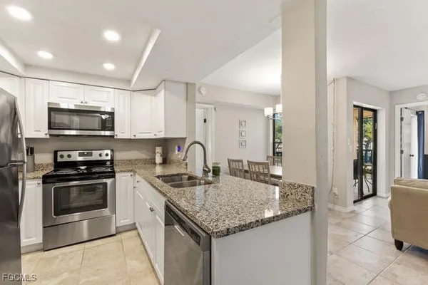a kitchen with stainless steel appliances granite countertop a sink stove and microwave