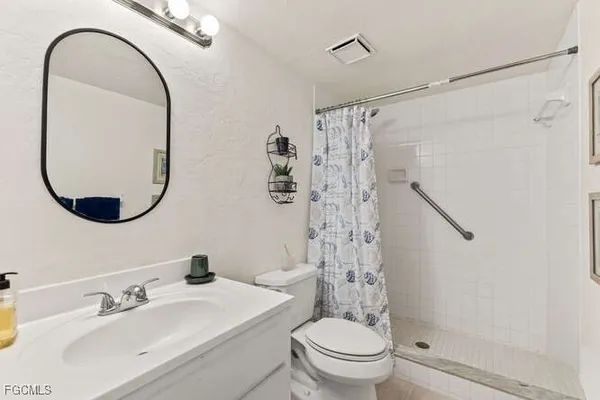 a bathroom with a sink a toilet and a mirror