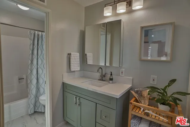 a bathroom with a sink a mirror and a shower