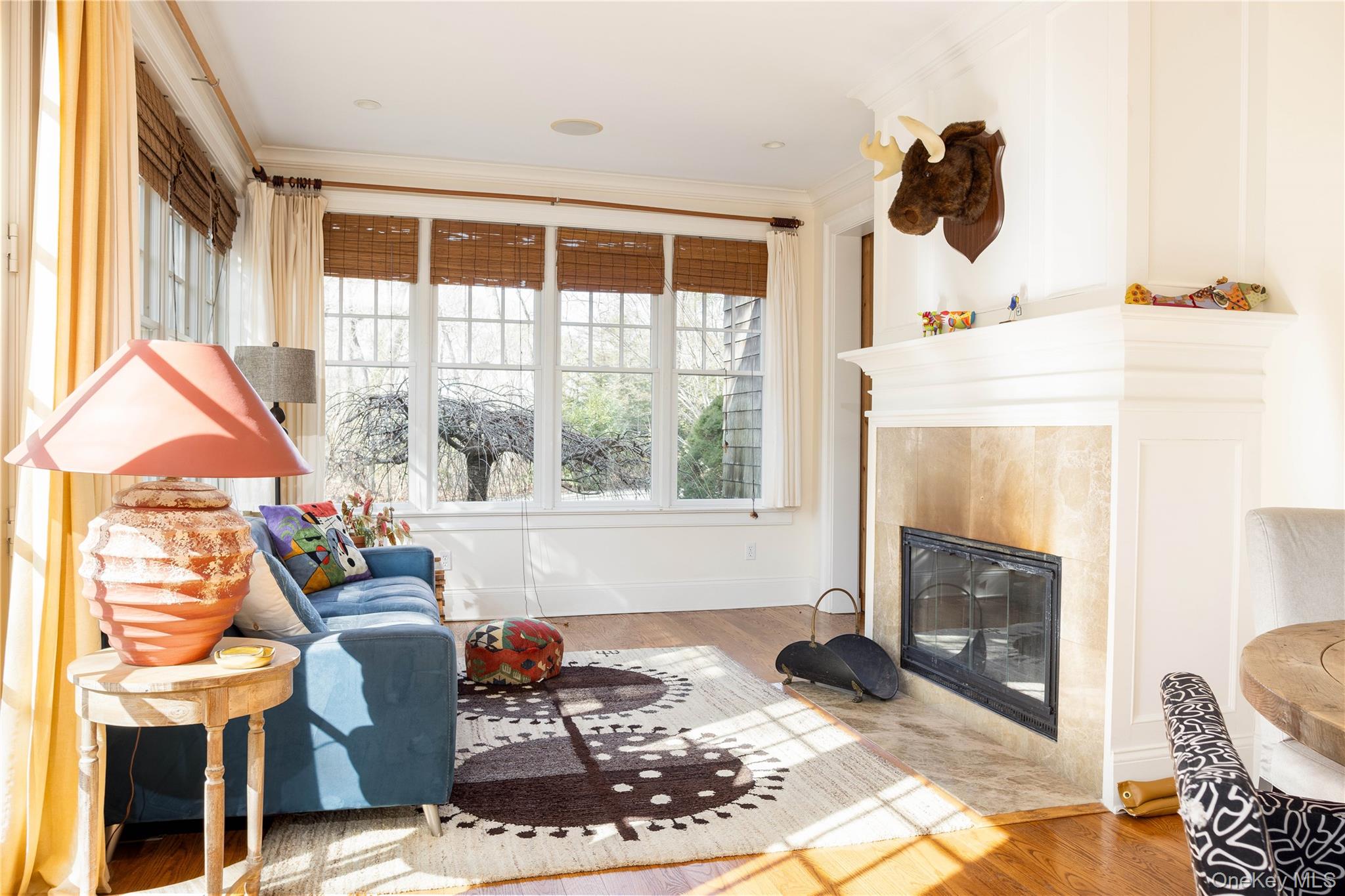 53 Cedar Lane West Remsenburg, NY 11960 - Photo 20 of 38 Living room featuring a fireplace, crown molding, and wood finished floors