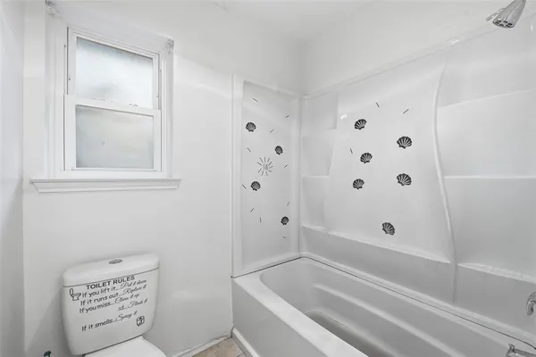 a bathroom with bathtub and window