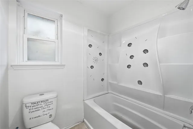 a bathroom with bathtub and window