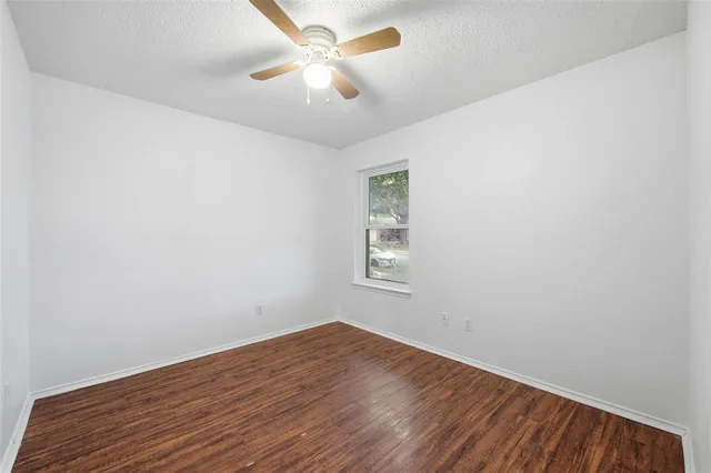 an empty room with a window and ceiling fan