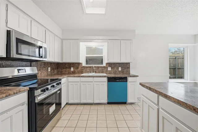 a kitchen with granite countertop cabinets stainless steel appliances and a sink
