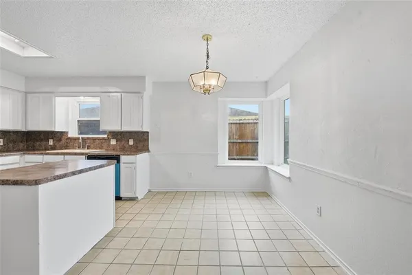 a kitchen with granite countertop white cabinets and window