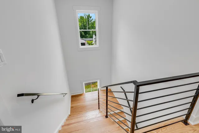 a view of a hallway with wooden floor and a window