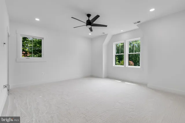 an empty room with a empty space and a ceiling fan