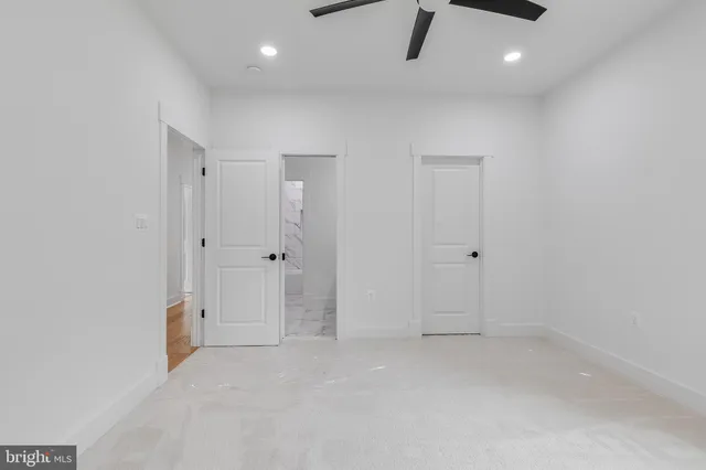 an empty room with a window and a fan