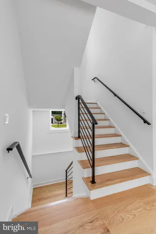 a front view of a house with a garden and trees