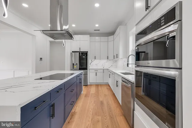 a large kitchen with a stove top oven and stainless steel appliances