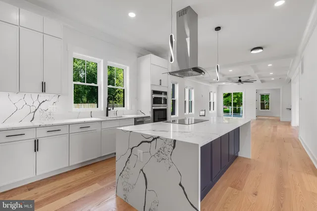 a kitchen with stainless steel appliances kitchen island a large island in the center and wooden floor