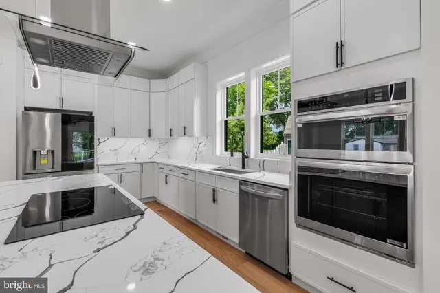 a kitchen with stainless steel appliances granite countertop a stove a microwave and a white cabinets