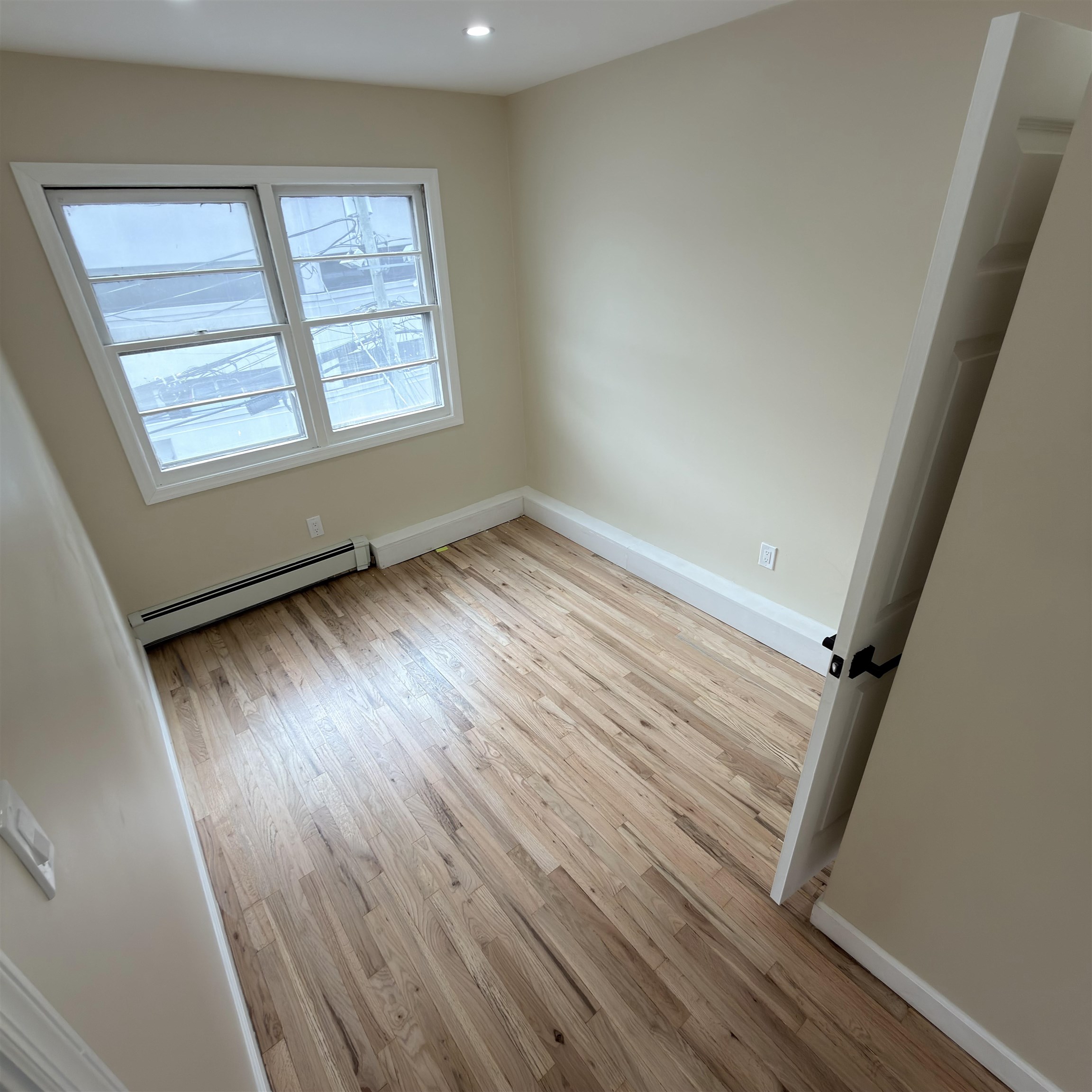 810 23rd Street, Unit 3 Union City, NJ 07087 - Photo 7 of 12 an empty room with wooden floor and windows