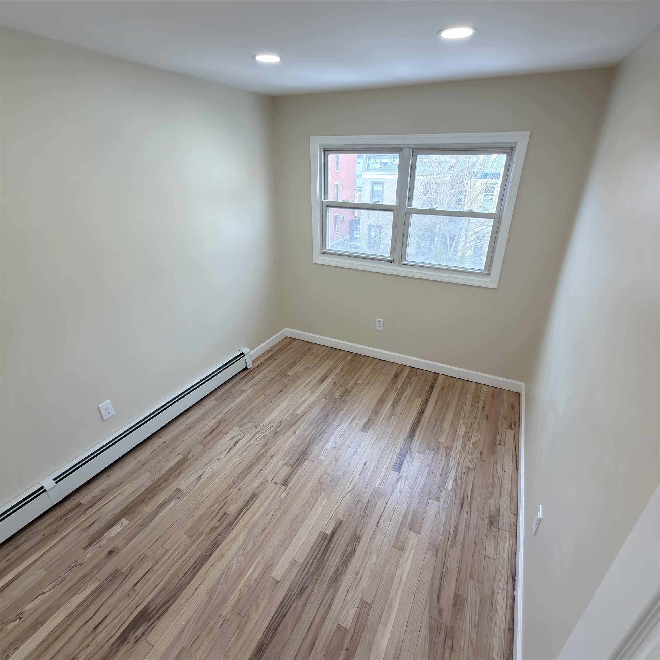 810 23rd Street, Unit 3 Union City, NJ 07087 - Photo 8 of 12 an empty room with wooden floor and windows