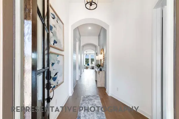 a view of a hallway with a livingroom and a hall with wooden floor