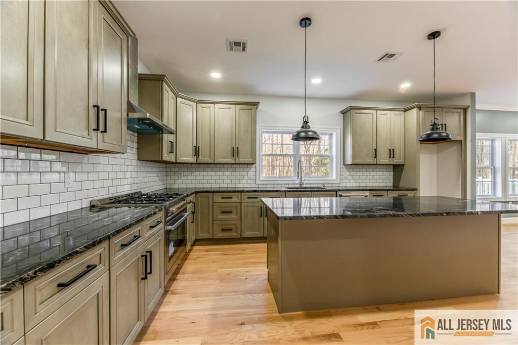 28 King George Road Warren, NJ 07059 - Photo 16 of 63 a kitchen with stainless steel appliances granite countertop a sink a stove and a wooden floors