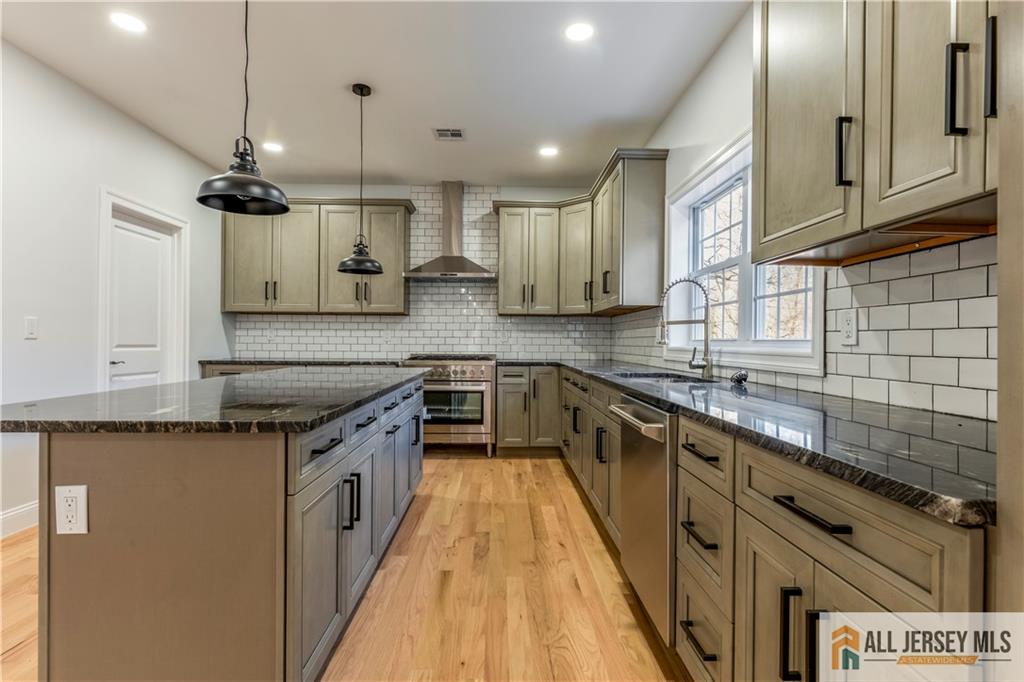 28 King George Road Warren, NJ 07059 - Photo 17 of 63 a kitchen with stainless steel appliances granite countertop a sink a stove and a wooden floors