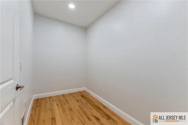 a view of a room with wooden floor and a bathroom