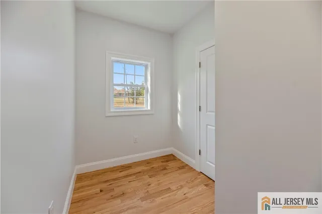 a view of a room with wooden floor and a window