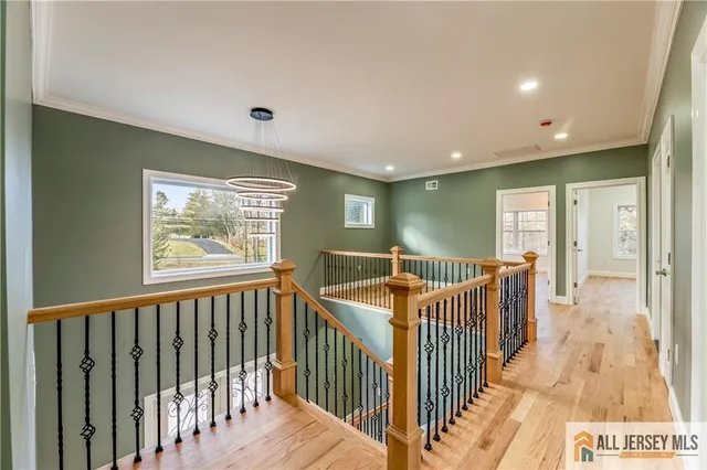 a view of a hallway with wooden floor and a bathroom