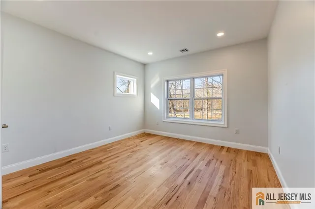 a view of a room with wooden floor and a bathroom