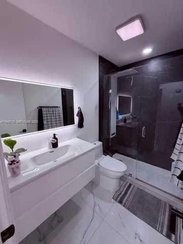 a bathroom with a sink a toilet and mirror