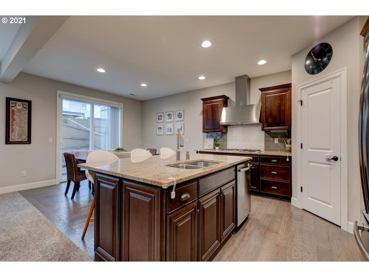 17468 Northwest Woodrush Way Portland, OR 97229 - Photo 11 of 32 a kitchen with a stove a refrigerator and a dining table