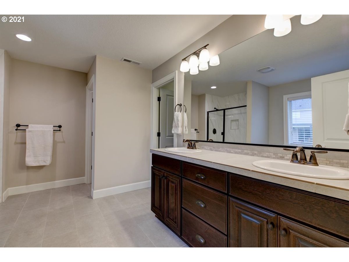 17468 Northwest Woodrush Way Portland, OR 97229 - Photo 15 of 32 a bathroom with a double vanity sink and mirror