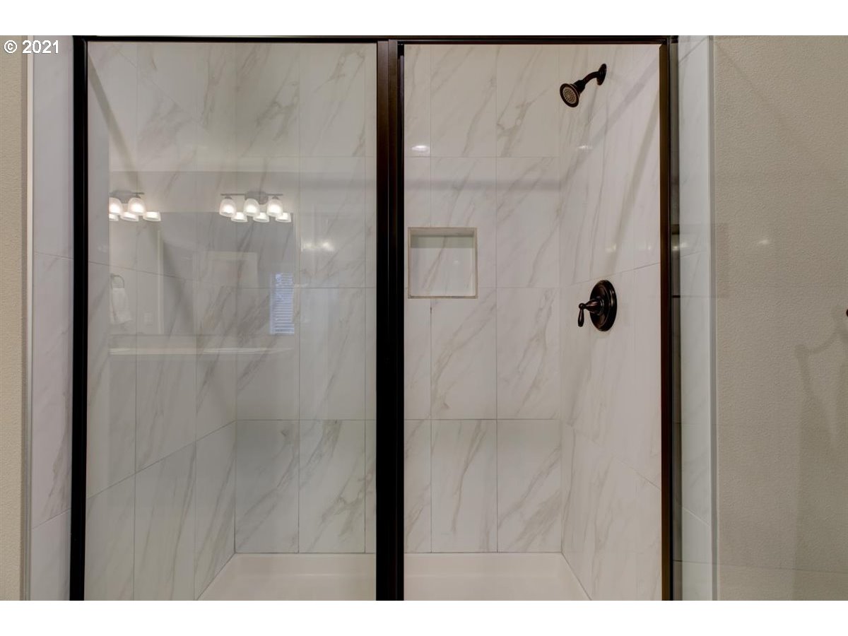 17468 Northwest Woodrush Way Portland, OR 97229 - Photo 16 of 32 a bathroom with a glass shower door