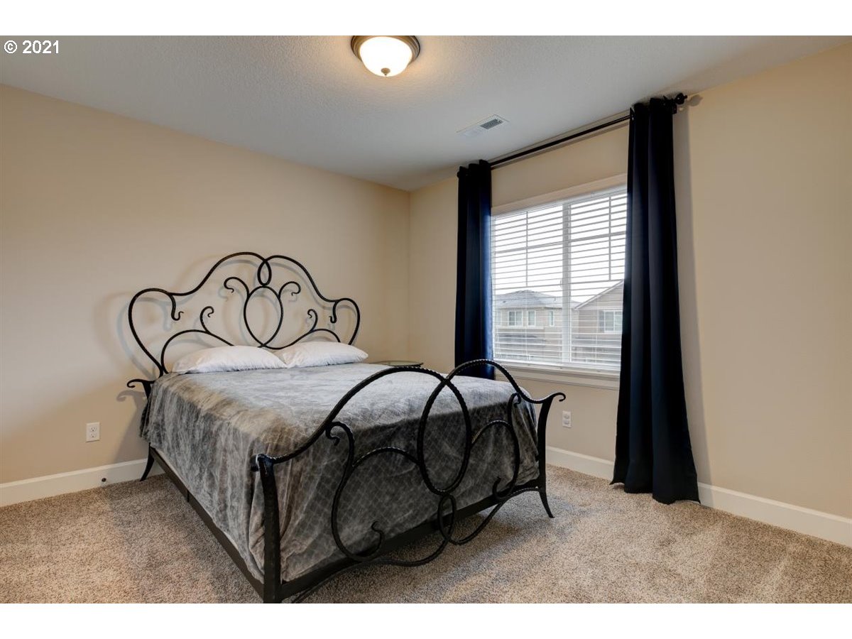17468 Northwest Woodrush Way Portland, OR 97229 - Photo 18 of 32 a bed sitting in a bedroom next to a window