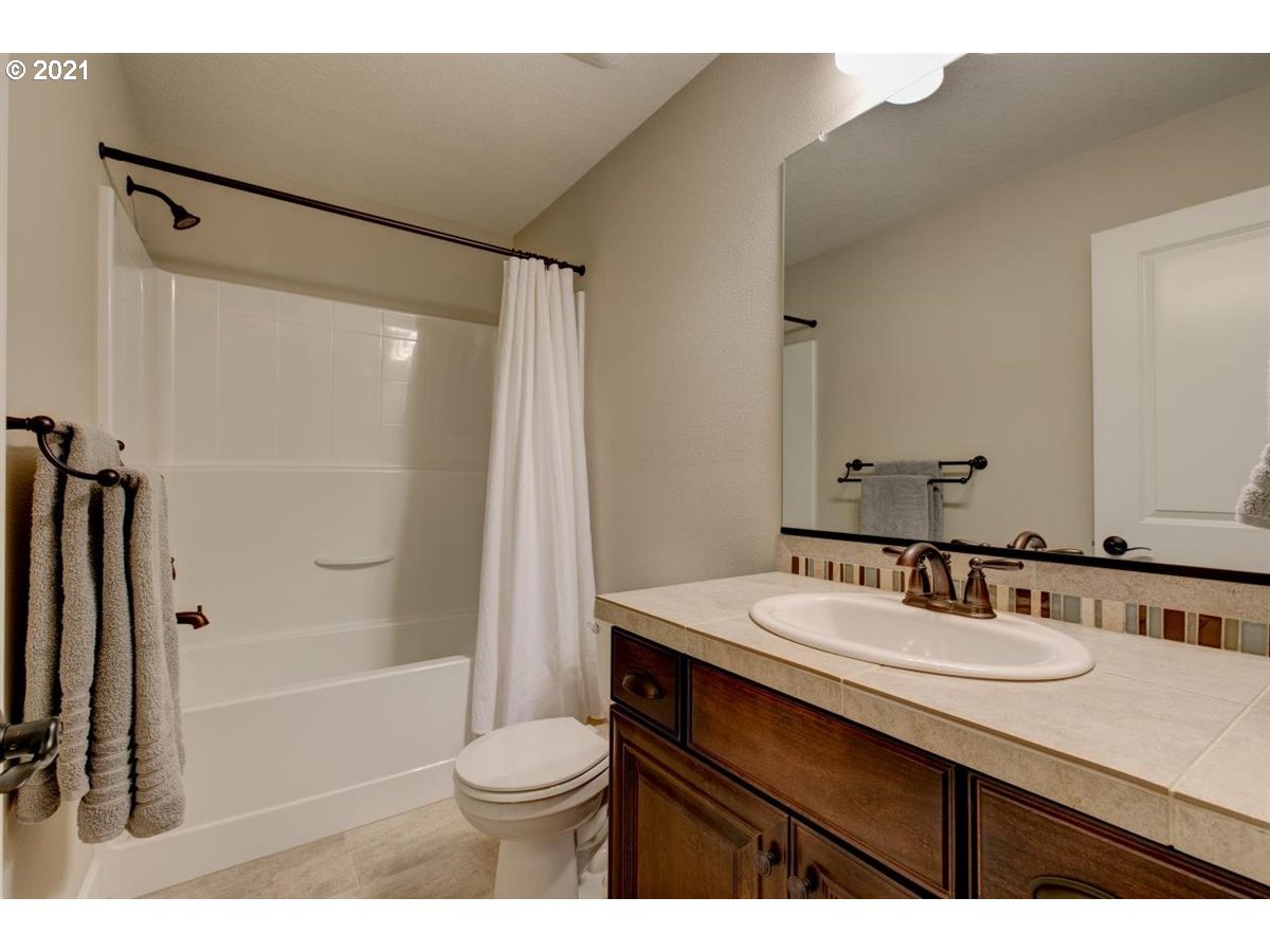 17468 Northwest Woodrush Way Portland, OR 97229 - Photo 25 of 32 a bathroom with a sink a toilet a mirror and shower