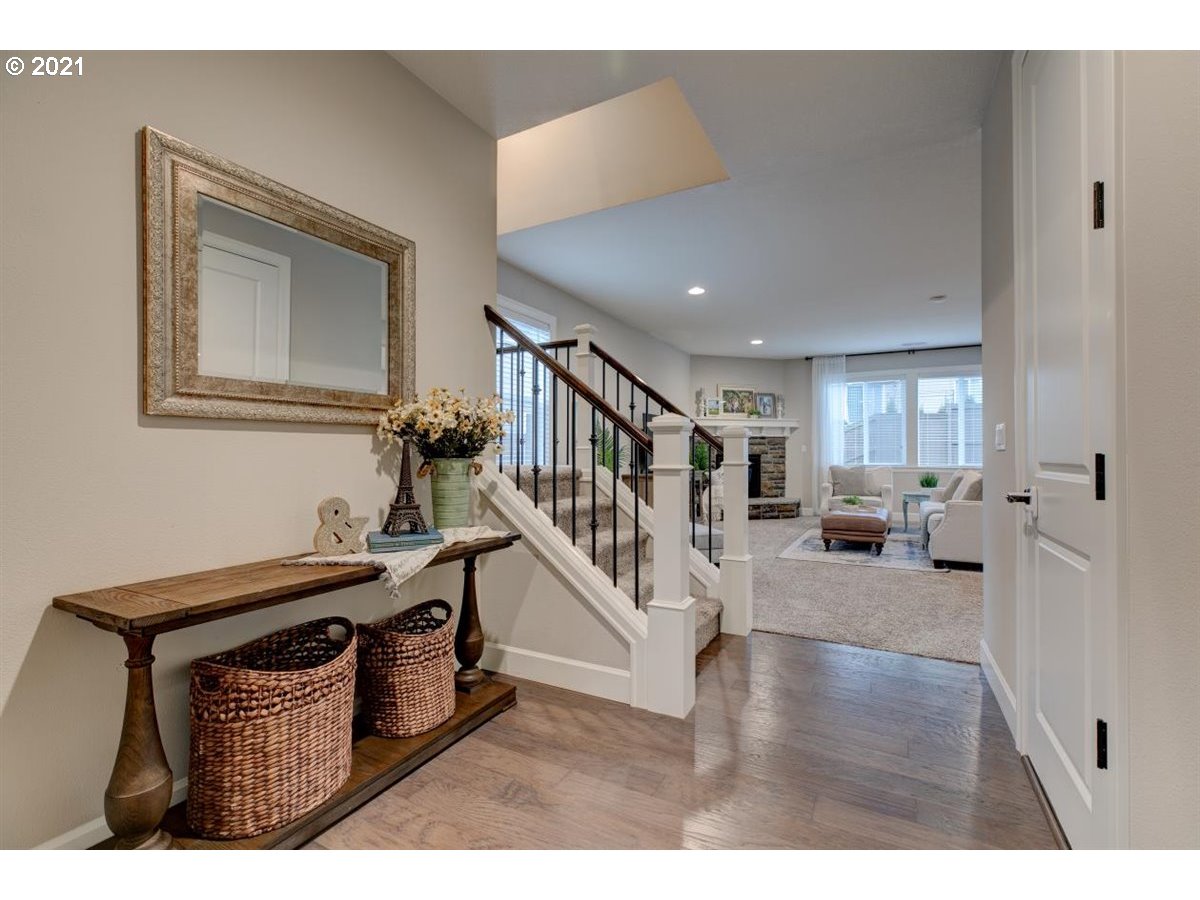 17468 Northwest Woodrush Way Portland, OR 97229 - Photo 3 of 32 a view of a livingroom with furniture stairs wooden floor and windows