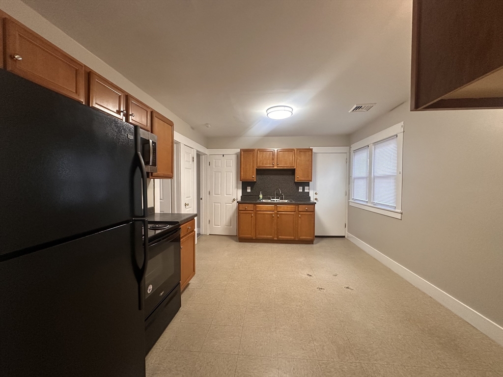 383 Newbury Street, Unit 2 Springfield, MA 01104 - Photo 2 of 11 a view of kitchen with furniture a refrigerator and windows
