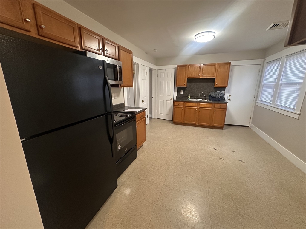 383 Newbury Street, Unit 2 Springfield, MA 01104 - Photo 4 of 11 a kitchen with stainless steel appliances a refrigerator and a stove
