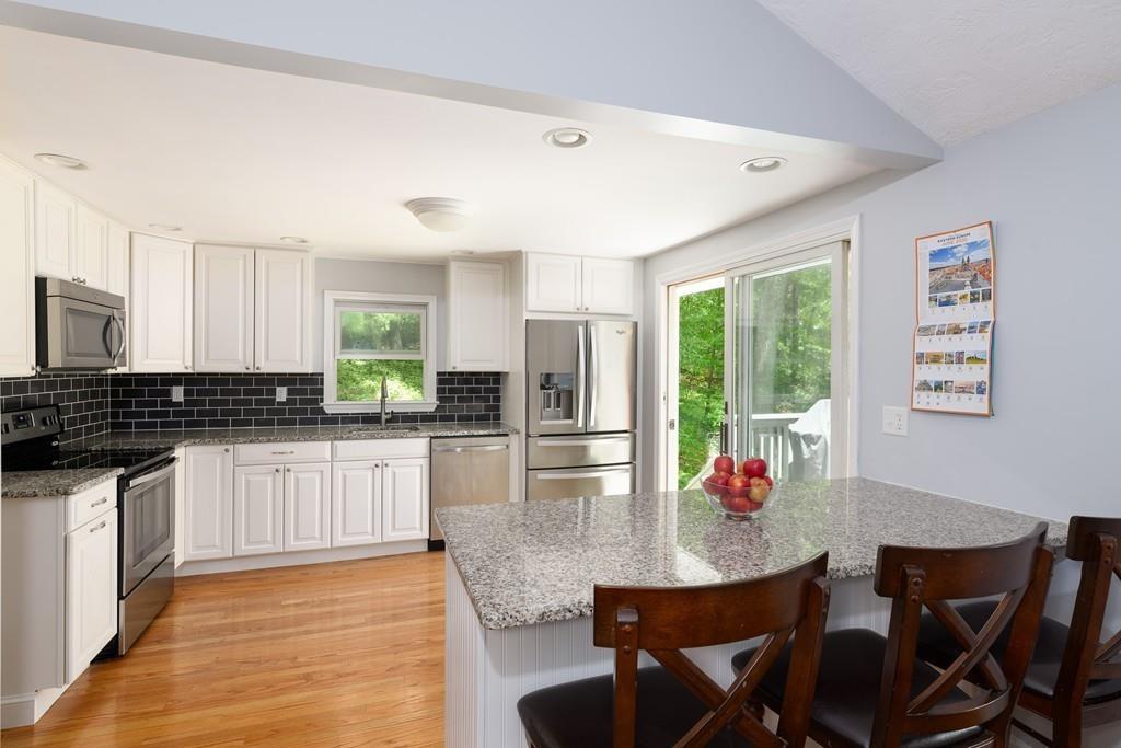 9 Highgate Road Wayland, MA 01778 - Photo 4 of 21 a kitchen with kitchen island granite countertop a dining table chairs and refrigerator