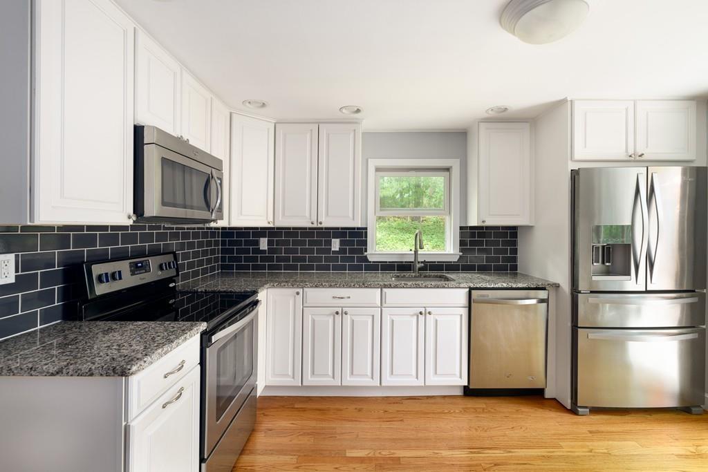 9 Highgate Road Wayland, MA 01778 - Photo 5 of 21 a kitchen with stainless steel appliances granite countertop a sink stove and refrigerator
